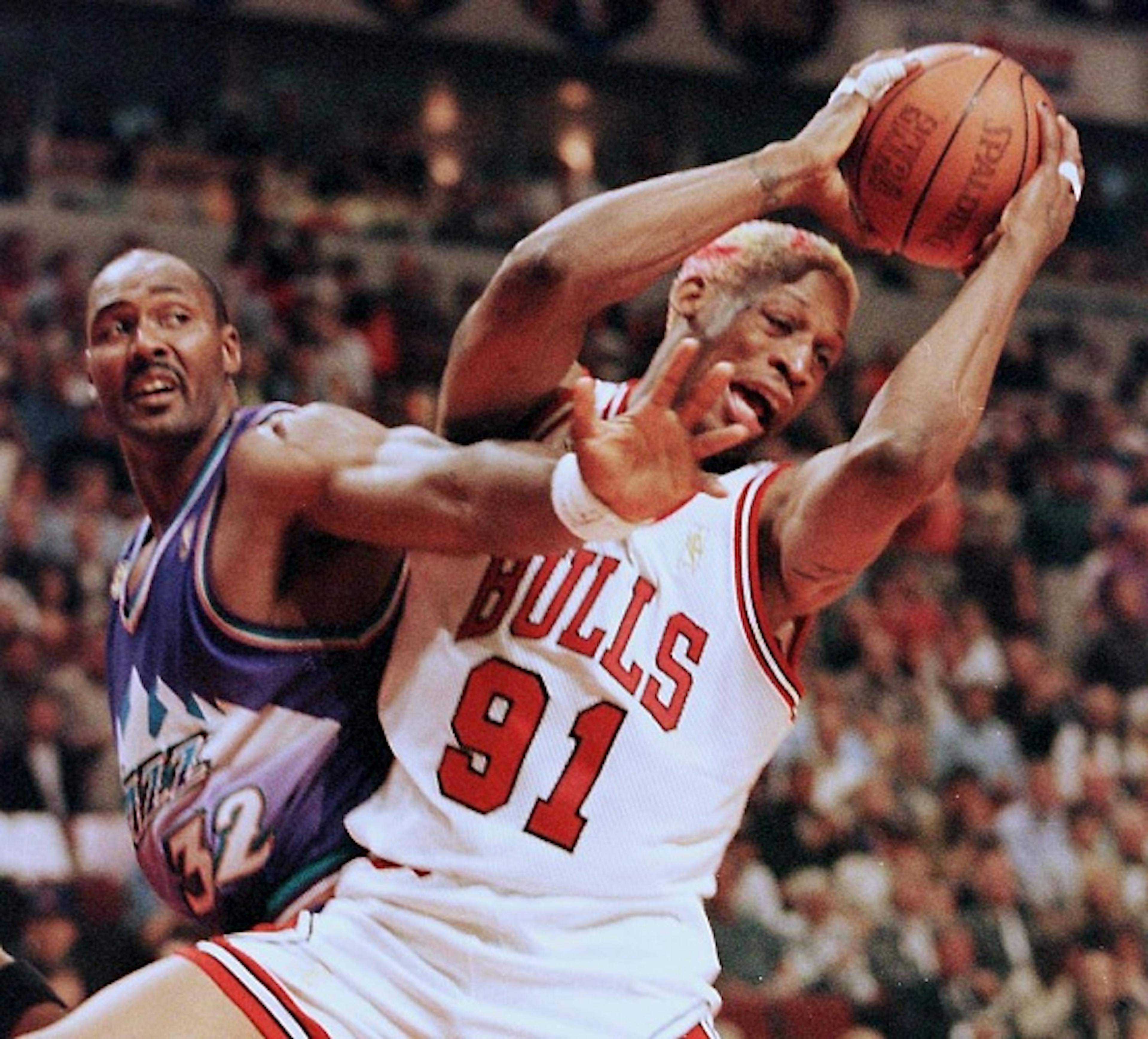 Dennis Rodman (R) of the Chicago Bulls grabs a rebound from Karl Malone (L) of the Utah Jazz 01 June during the second half of game one of the NBA Finals at the United Center in Chicago, Illinois.