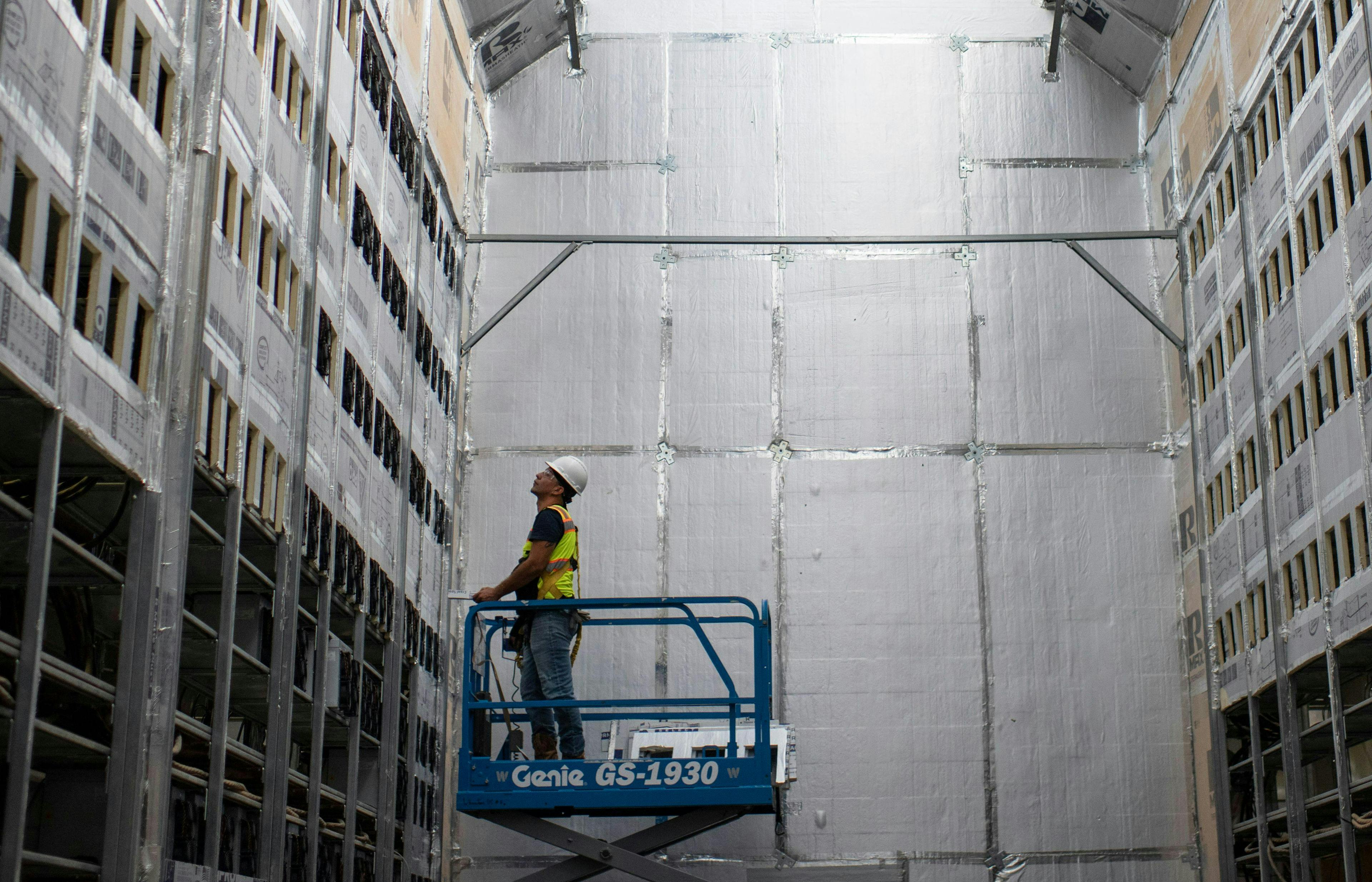 A worker installs a new row of Bitcoin mining machines 