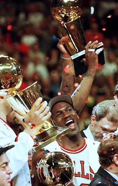 Chicago Bulls player Michael Jordan is surrounded by NBA Championship trophies after his team defeated the Utah Jazz 90-86 to win the 1997 NBA Finals at the United Center in Chicago, IL.