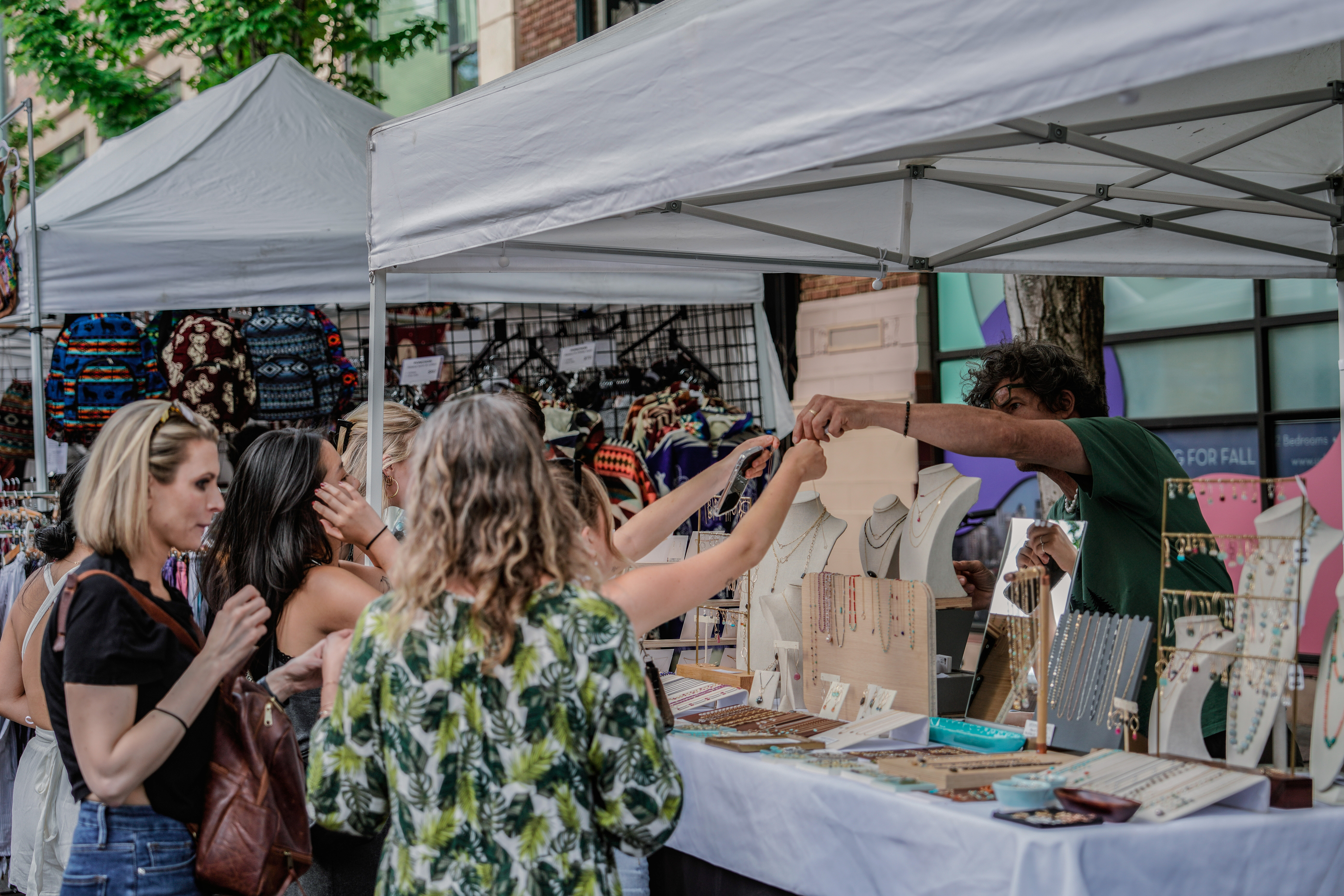 A customer is seen buying the works of an artist at the U District Street Fair. 
