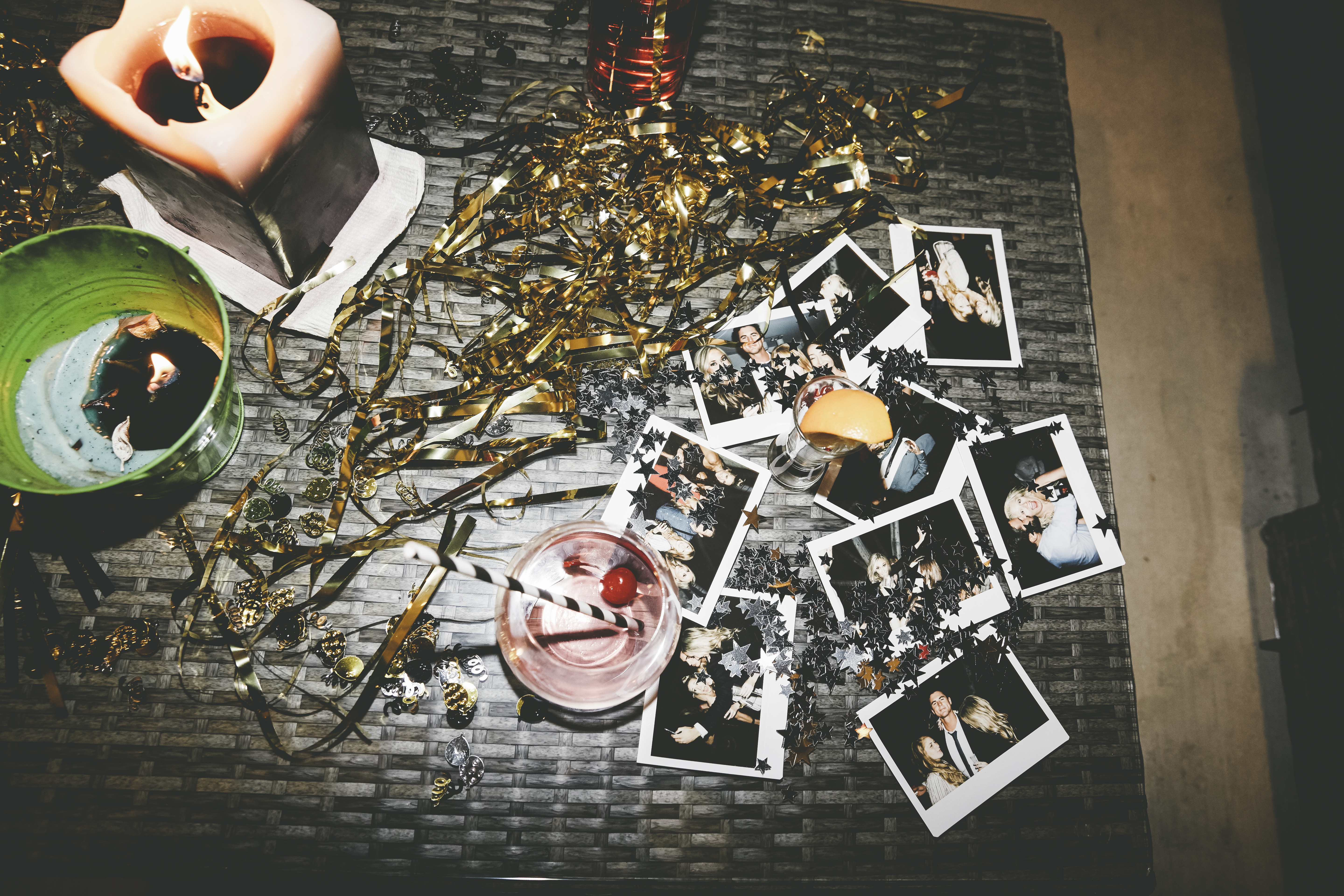 Photo of a table at a party with streamers and polaroid photos on it. 
