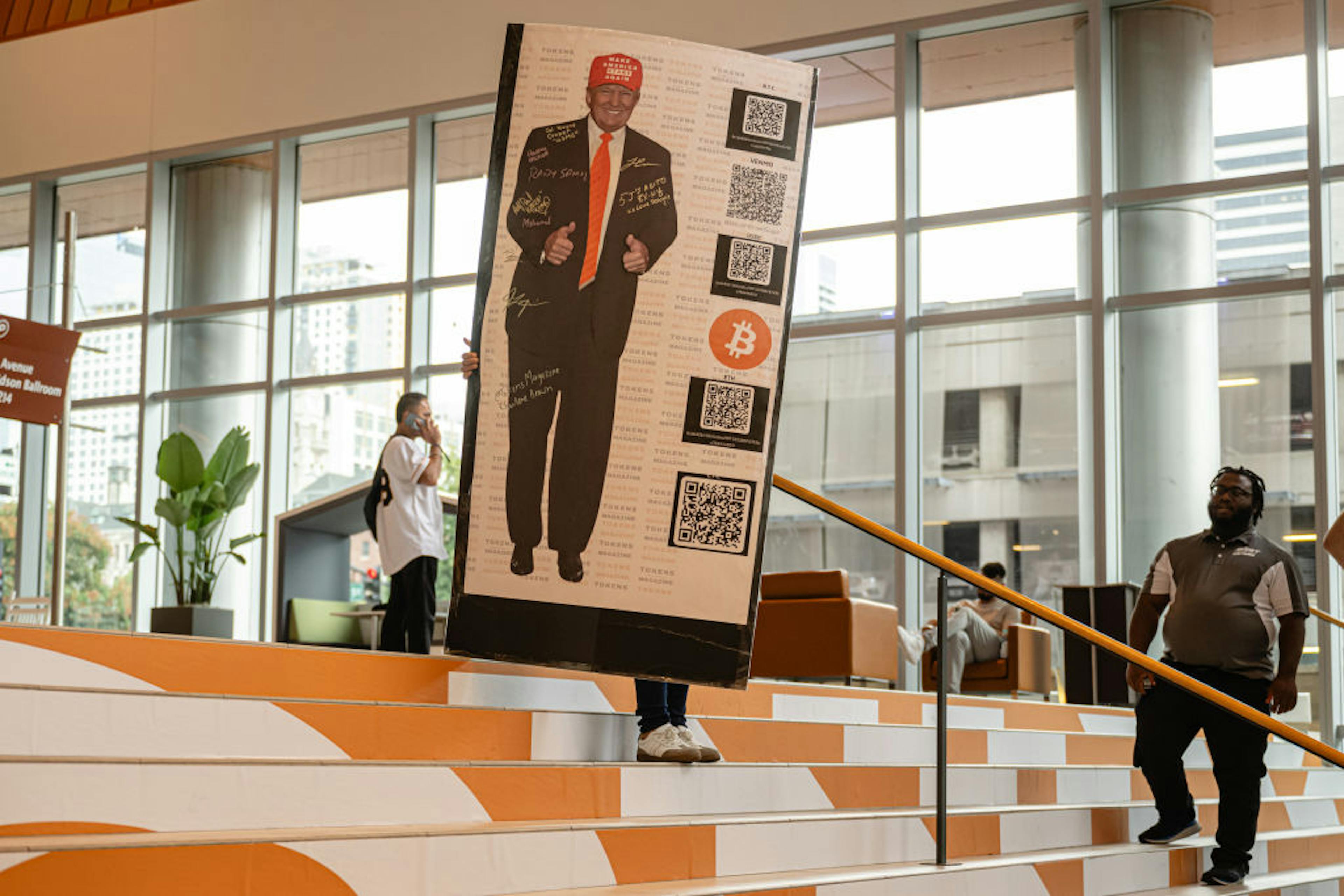 A staff member carries a standee of former President Donald Trump in the convention area of the Bitcoin 2024 conference at Music City Center July 26, 2024 in Nashville, Tennessee. 