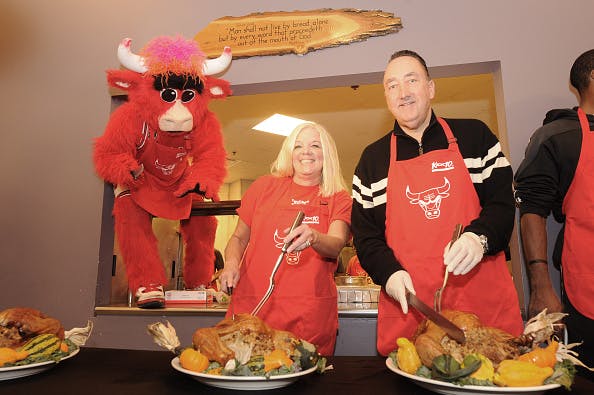 CHICAGO, IL - NOVEMBER 09: Chicago Bulls General Manager Gar Forman (R) and Chicago Bulls Charities Vice President Nancy Forman prepare to carve turkeys while mascot Benny the Bull observes during the team's 12th Annual Thanksgiving Dinner.