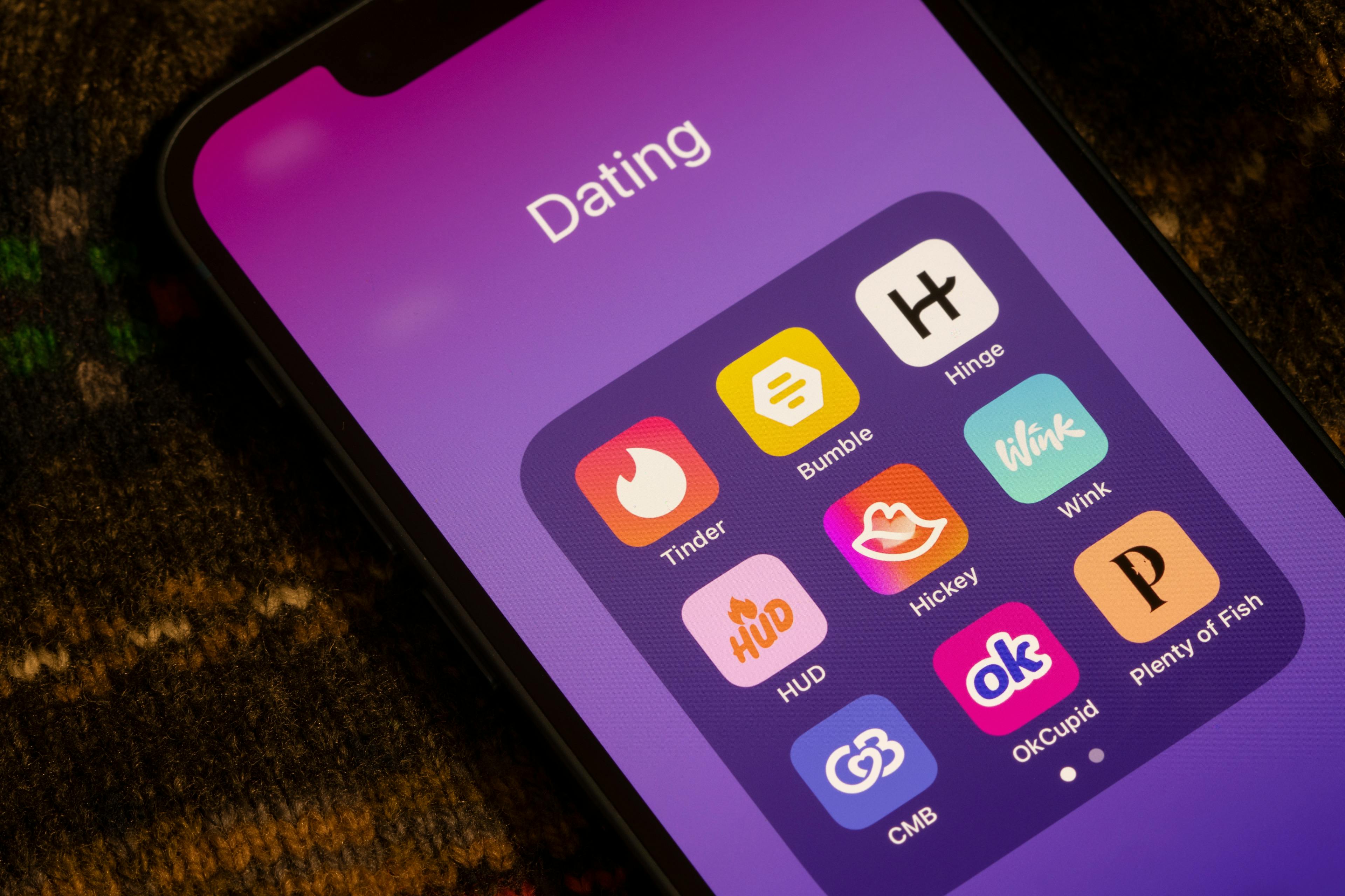 a phone screen showing dating apps including Tinder, Bumble, Hinge