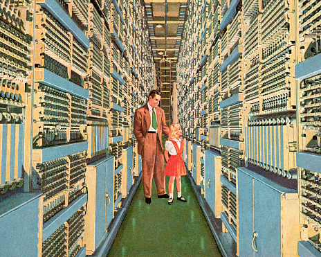 Man and Girl Walking Through Aisle of Computers