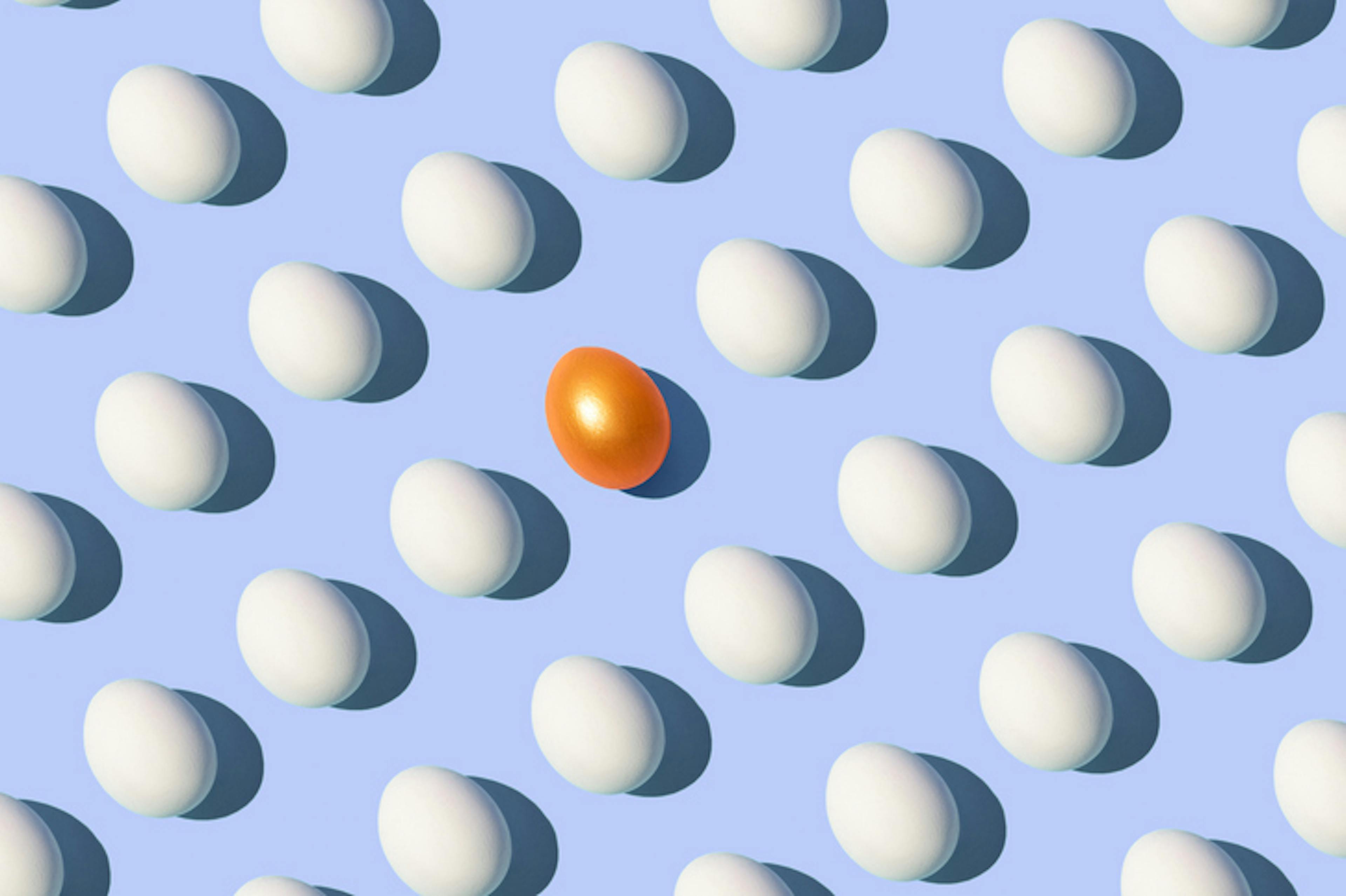 Golden egg surrounded by white eggs