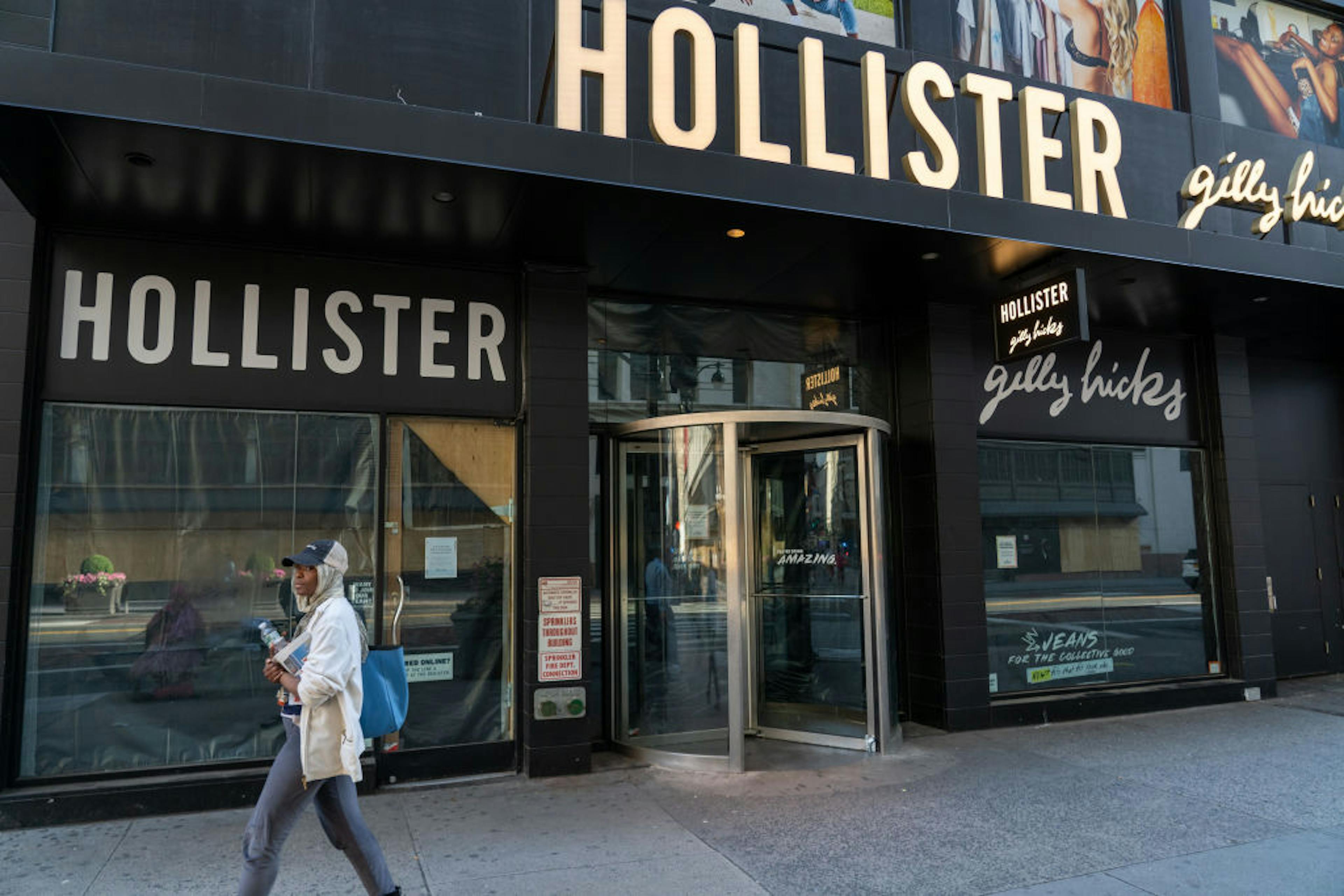 A woman walks past a Hollister store under restoration in...