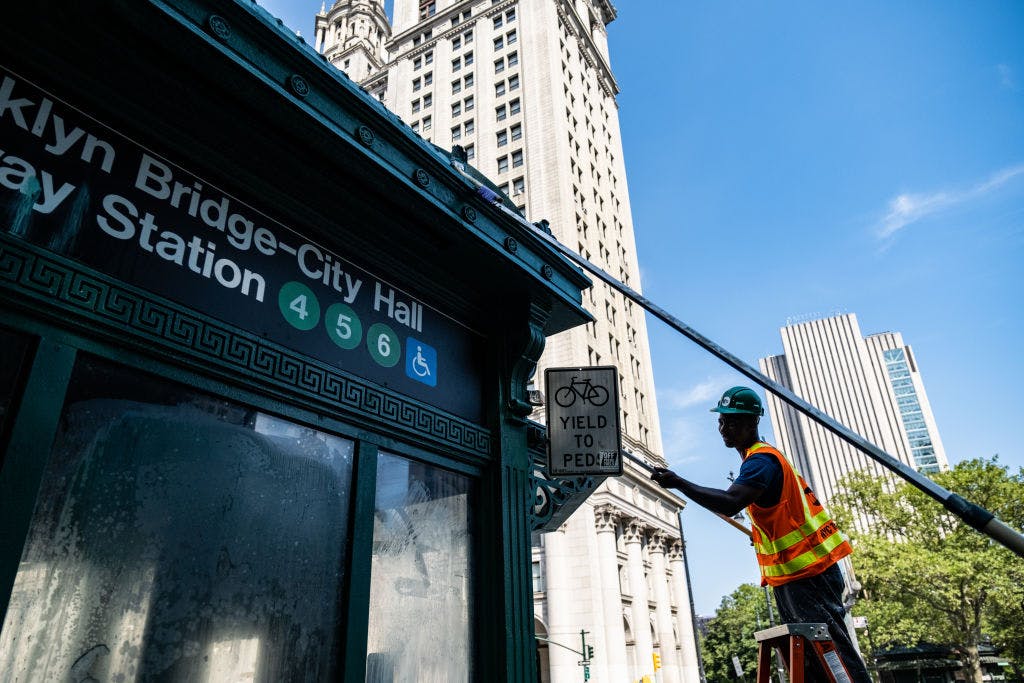 Worker painting subway entrance