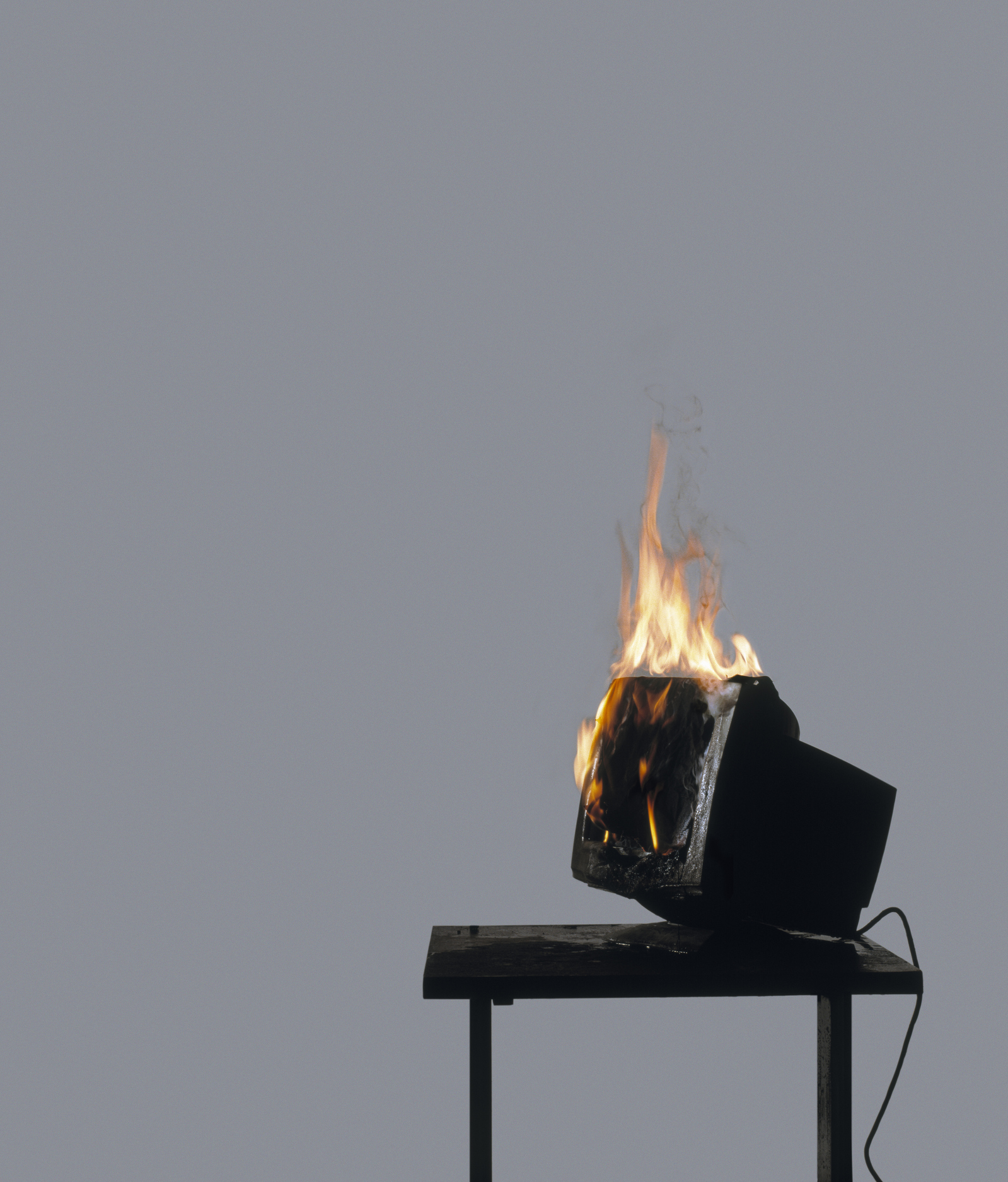 Computer terminal on fire on table (Digital Composite)