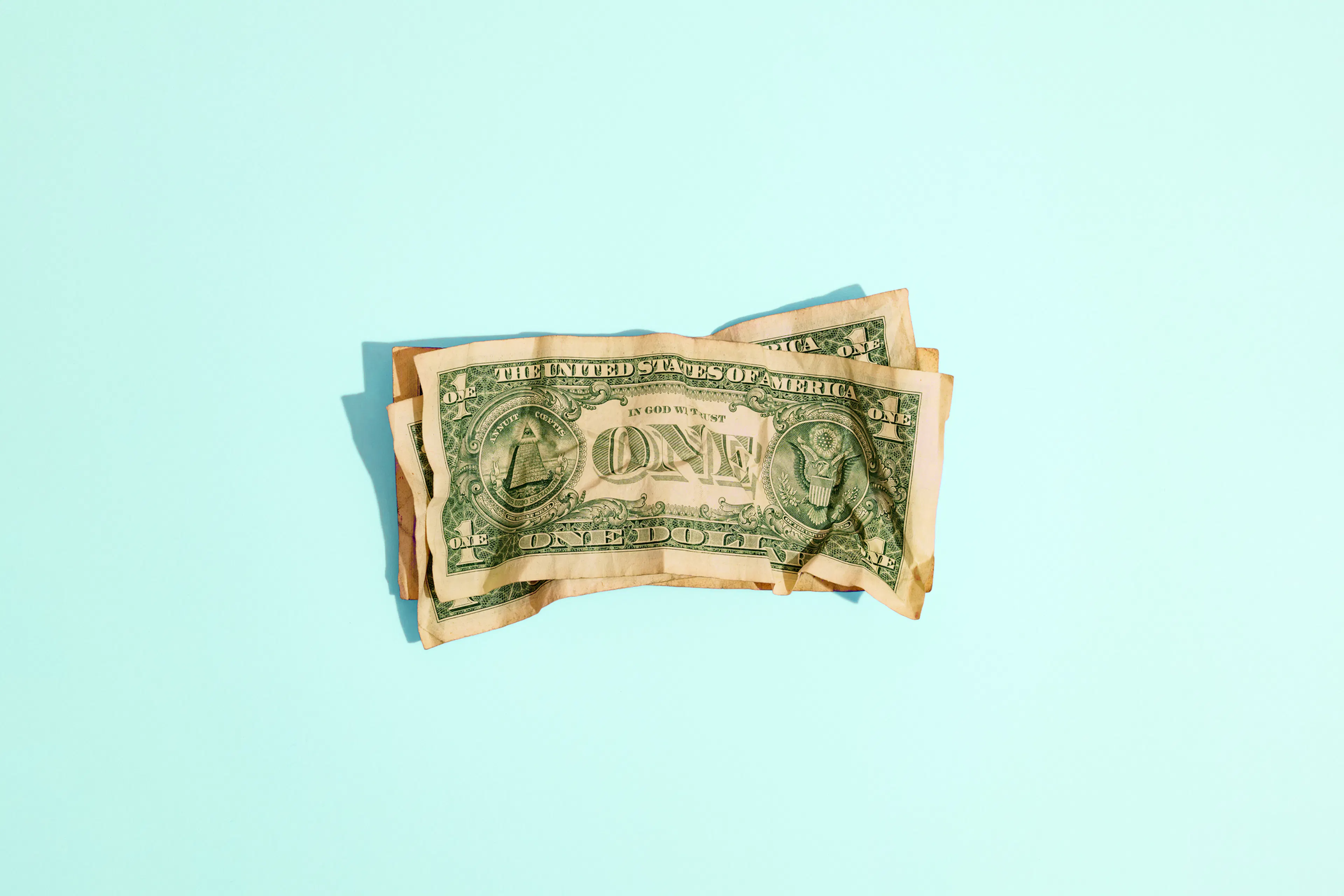 Crumpled One Dollar Notes Isolated on Blue Background