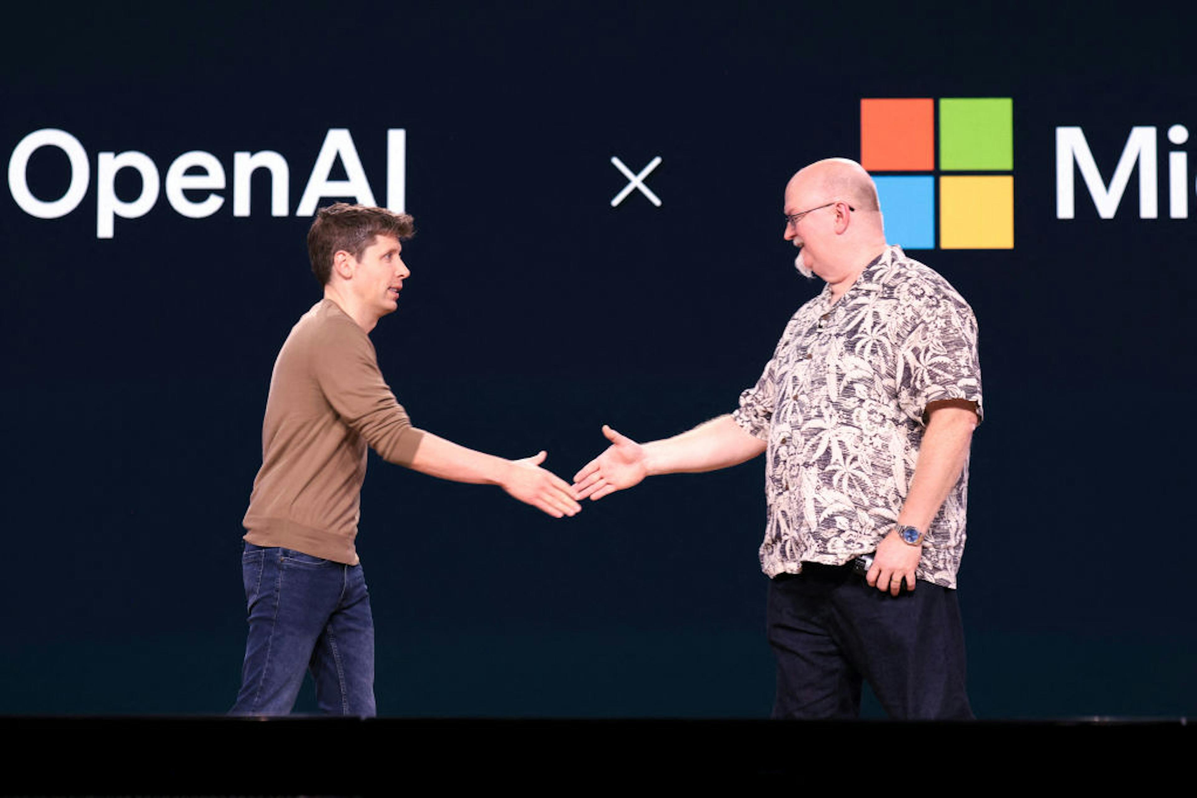 OpenAI CEO Sam Altman (L) shakes hands with Microsoft Chief Technology Officer and Executive VP of Artificial Intelligence Kevin Scott during the Microsoft Build conference