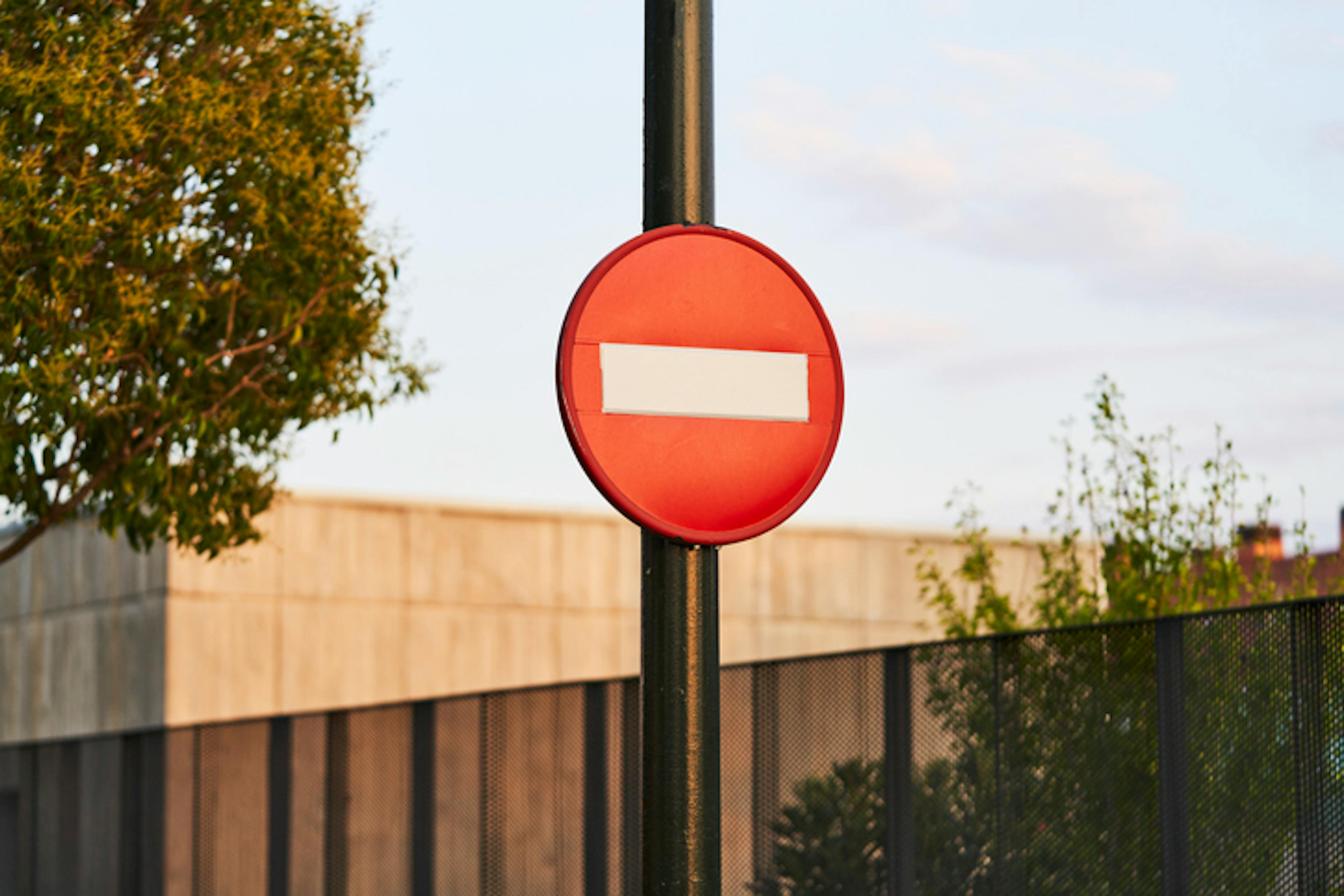 side view of a red stop sign on a metal pole on a city street with no people around it.