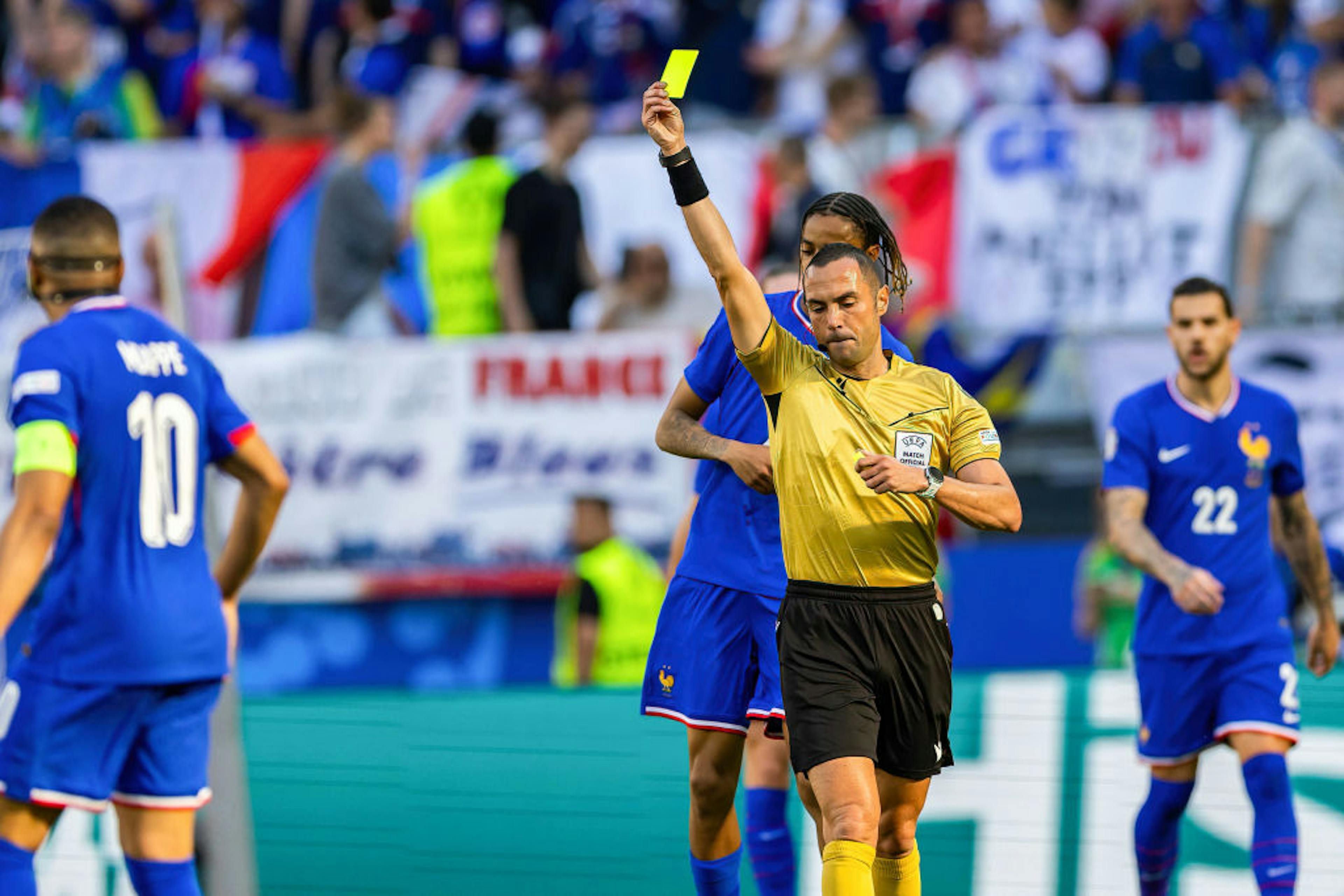 Referee Marco Guida shows a yellow card during the UEFA EURO