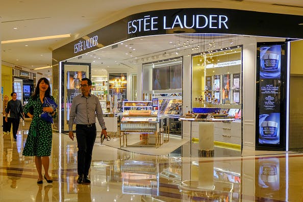 A couple walks by Estee Lauder store in Kuala Lumpur.