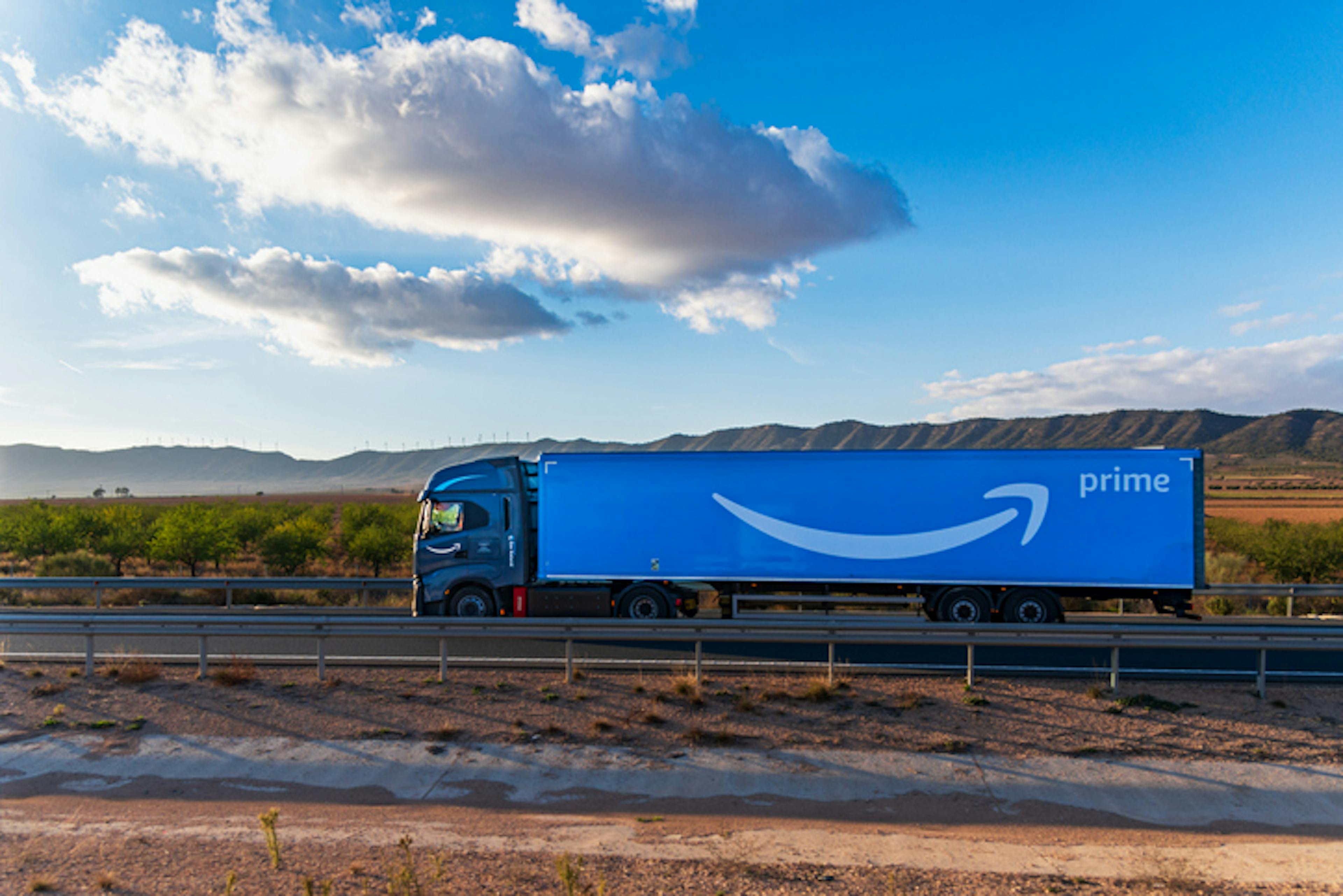 Amazon company truck driving on a highway, side view.