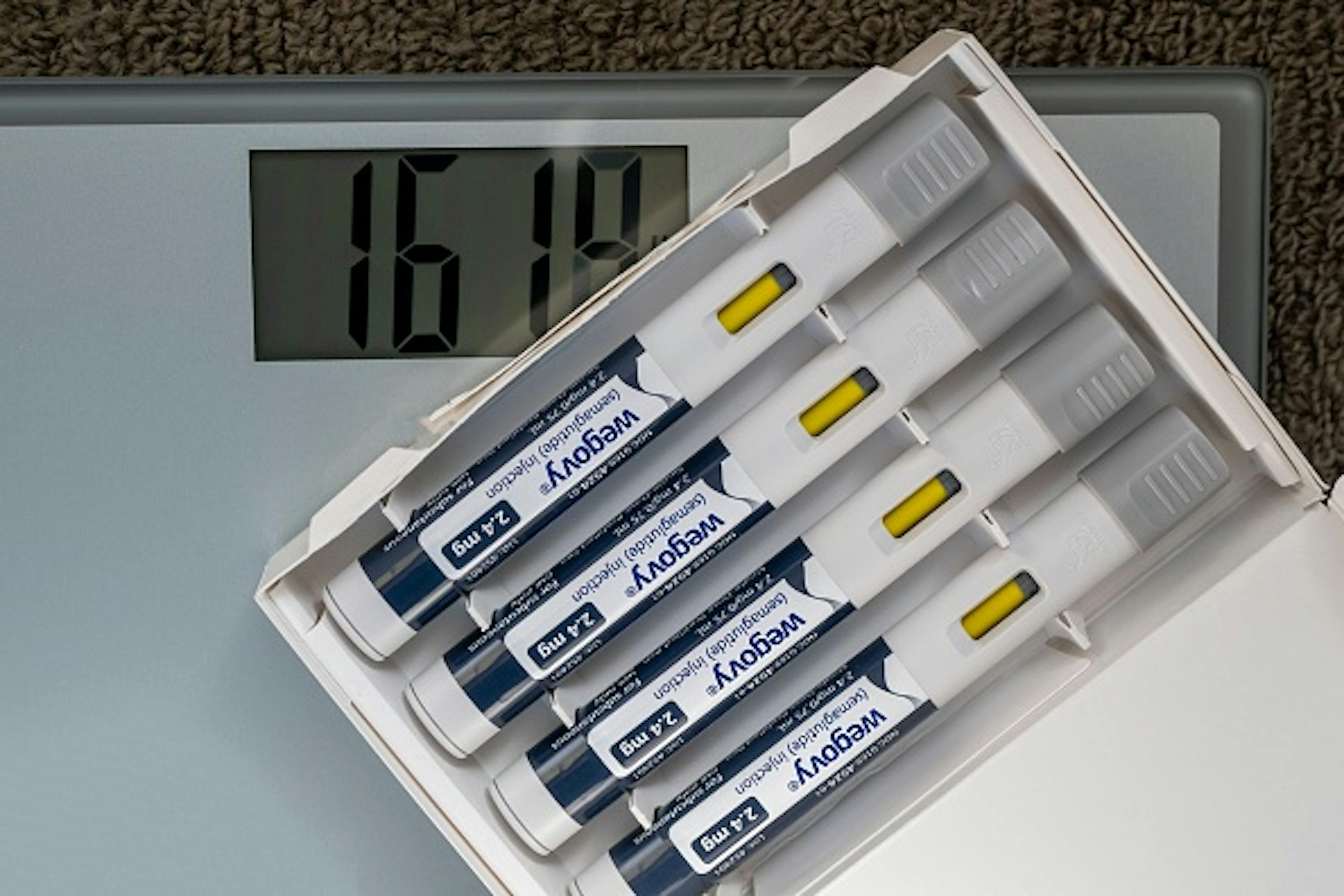 Still life of Wegovy with a weight scale.
