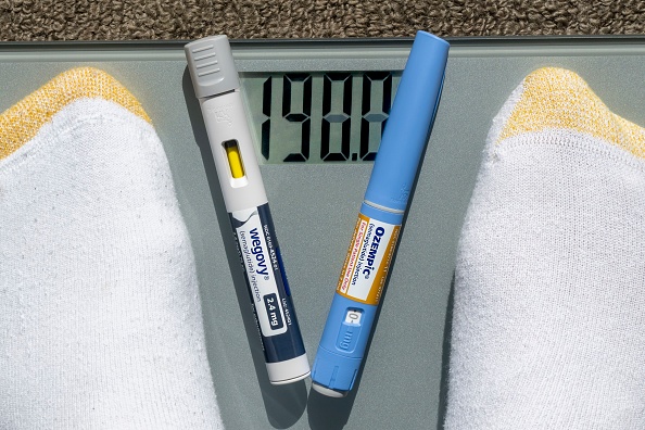 Still life of Ozempic and Wegovy with weight scale.