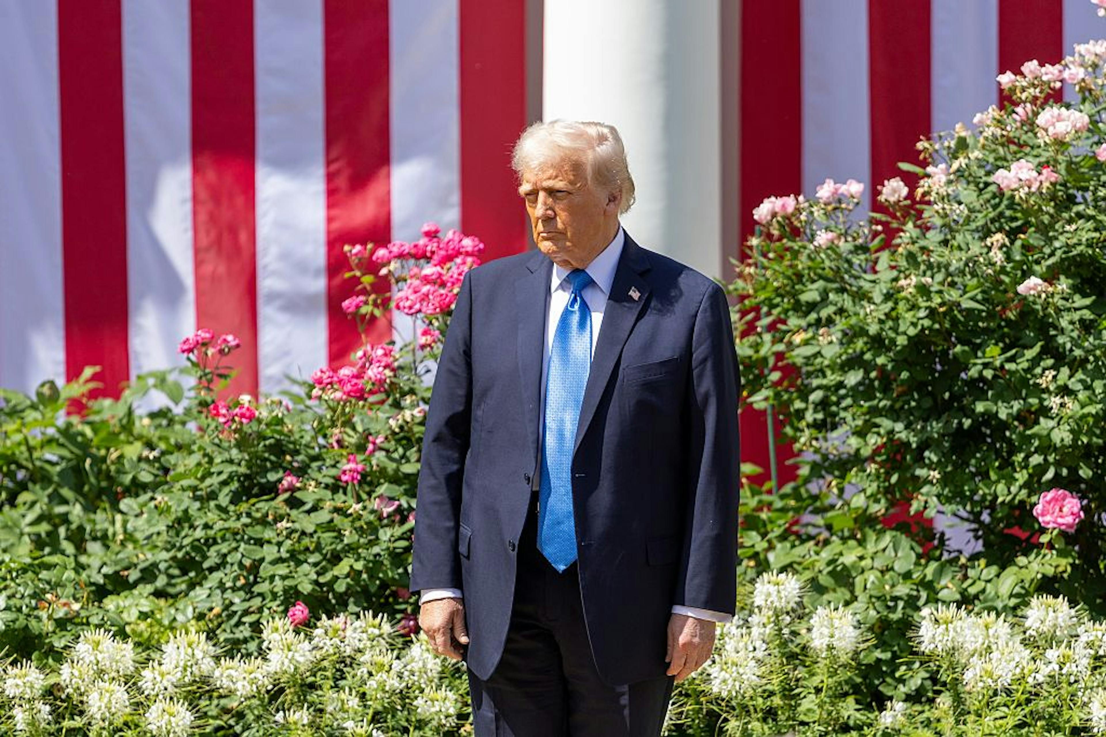 Trump frowning in front of flag
