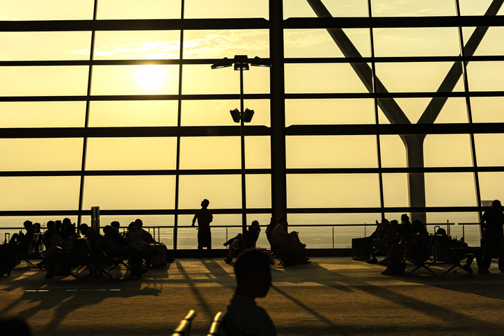 Silhouettes of passengers waiting at an airport