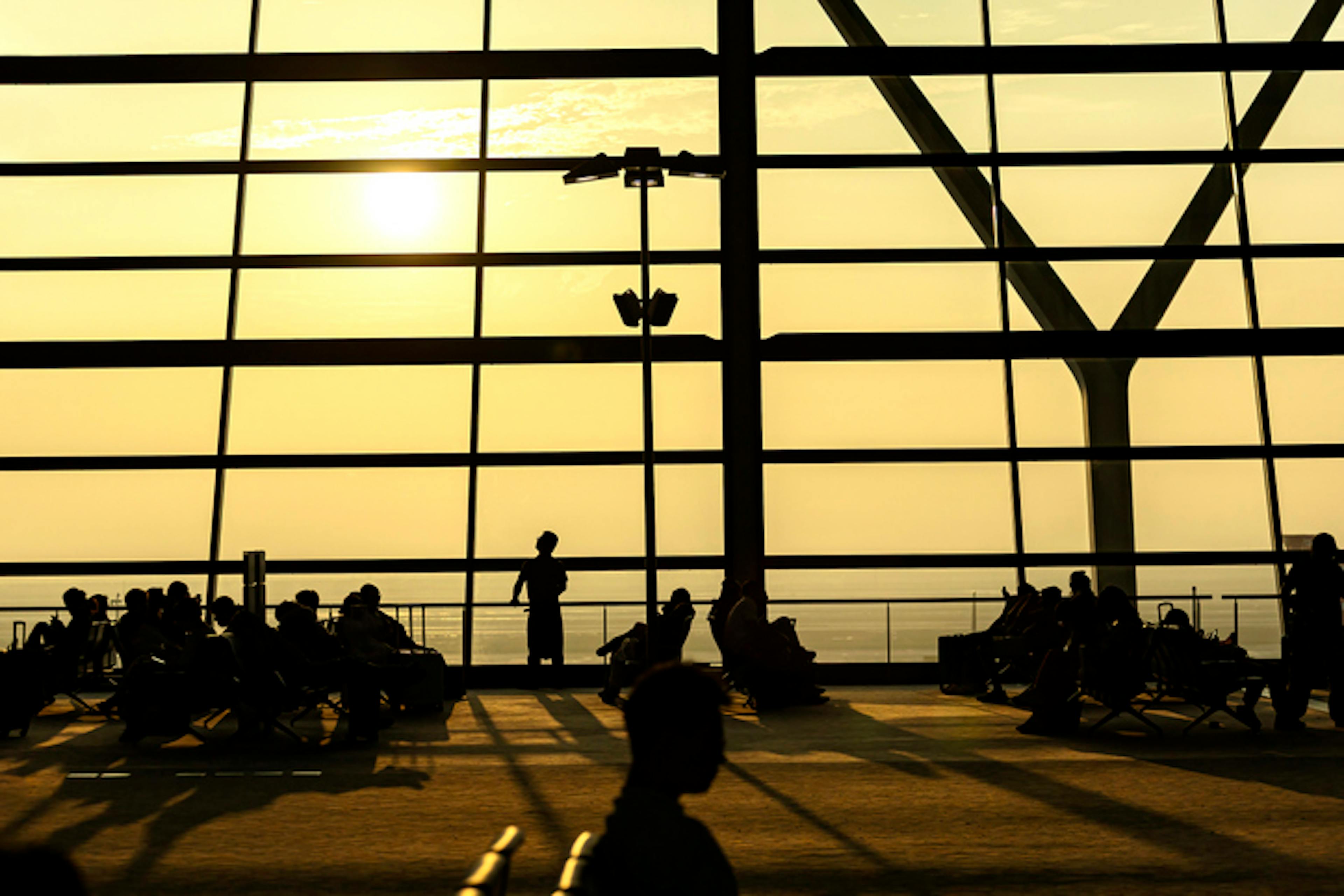 Silhouettes of passengers waiting at an airport
