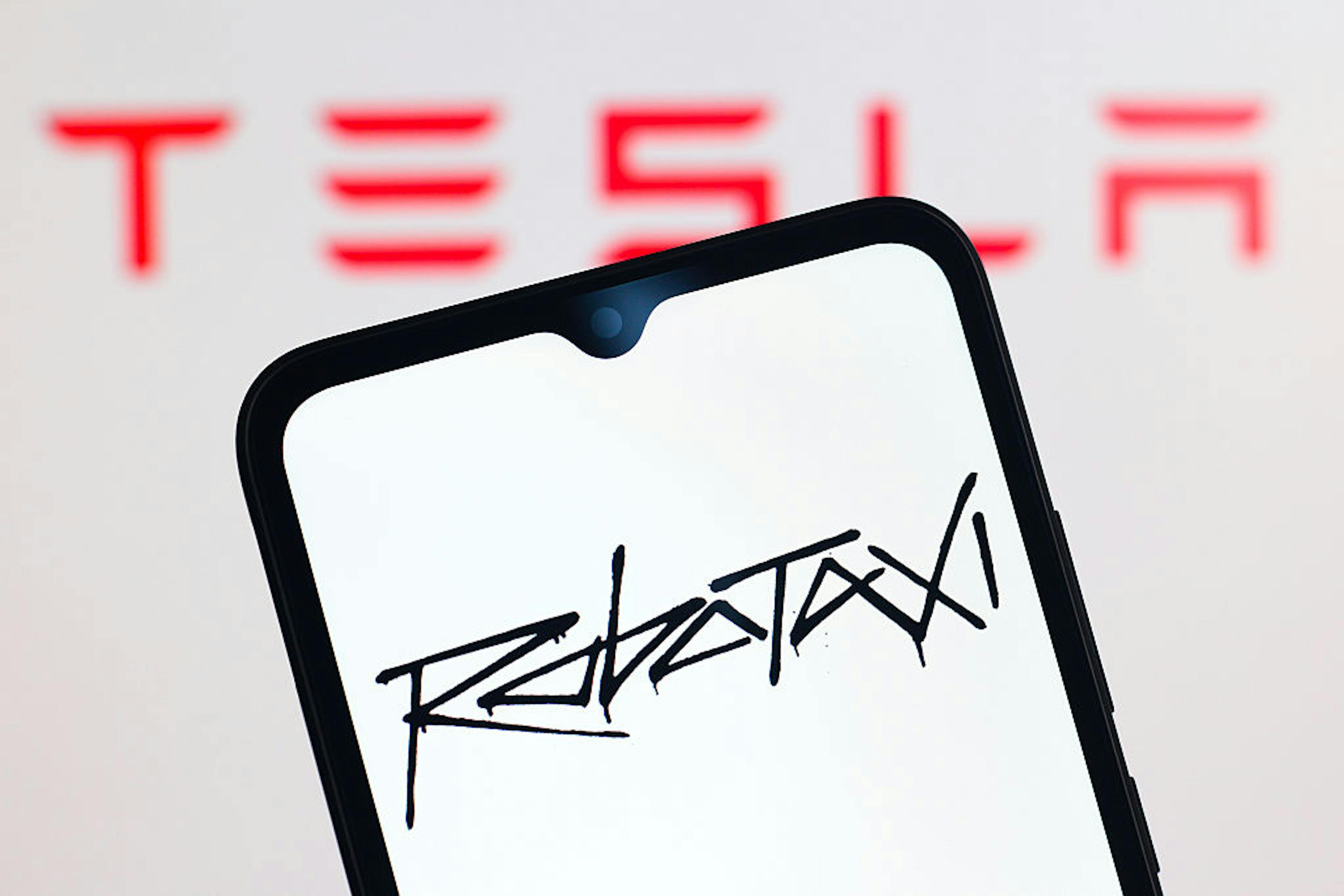 In this photo illustration, the Tesla Robotaxi logo is seen...