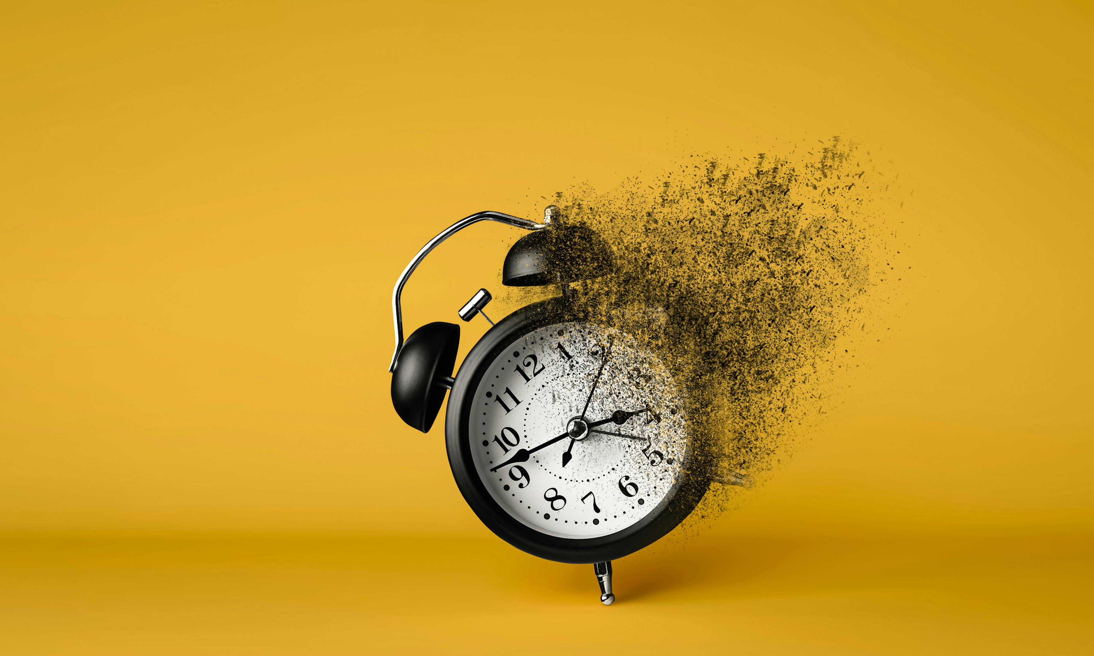 A black alarm clock dissolving on yellow background. Concept of importance of moments conveying time running out.