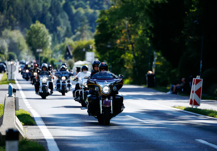 Harley-Davidson motorcycles cruising along scenic road during European Bike Week, showcasing vibrant atmosphere and camaraderie among riders