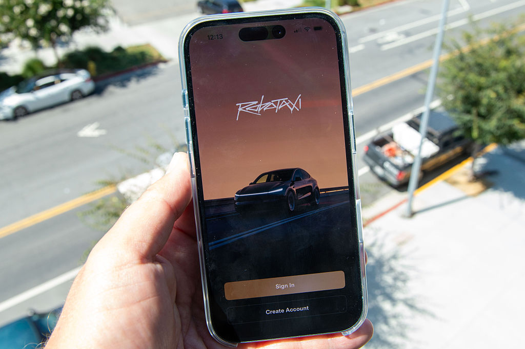 Tesla Robotaxi app person holding