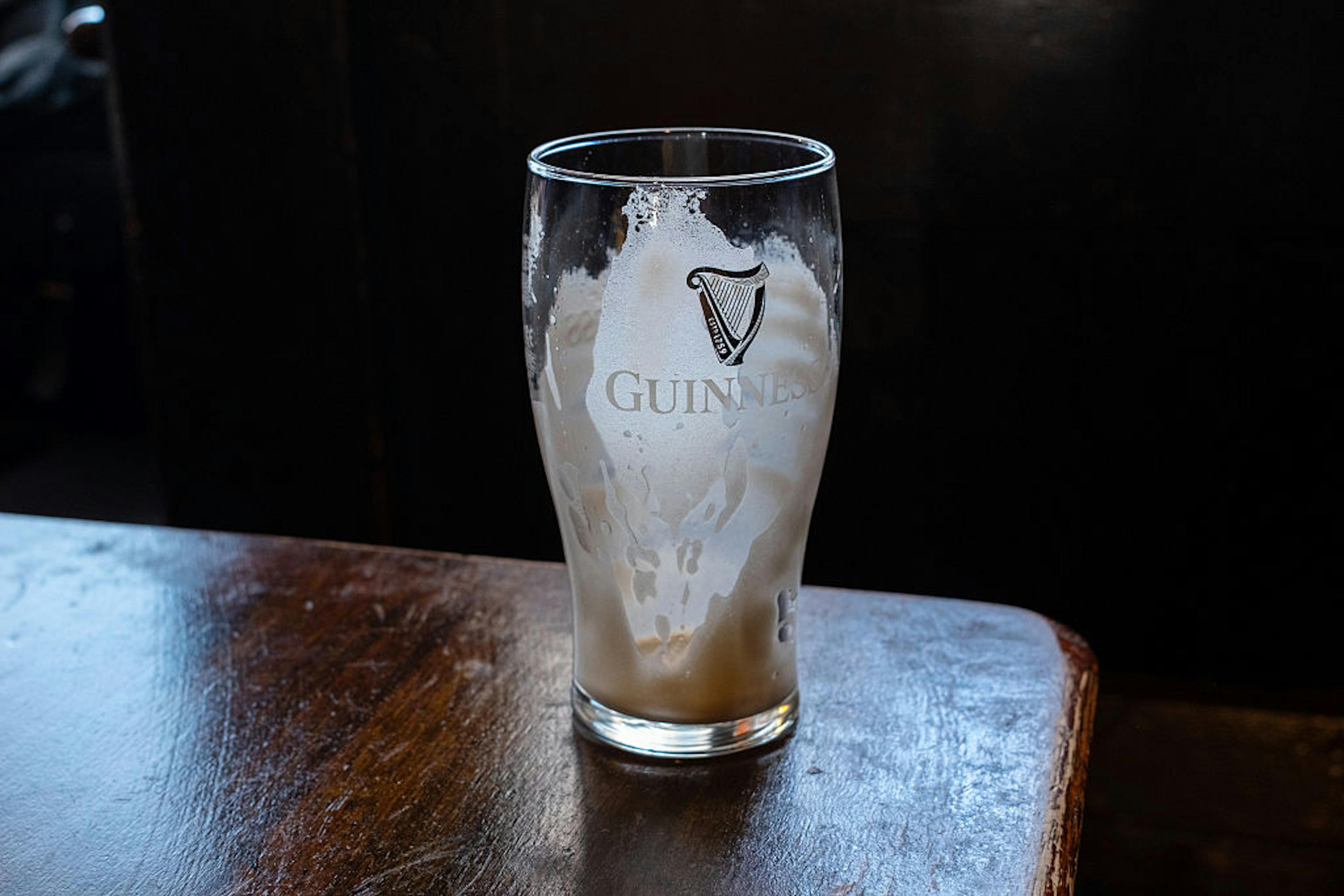 Empty glass of guinness on pub table