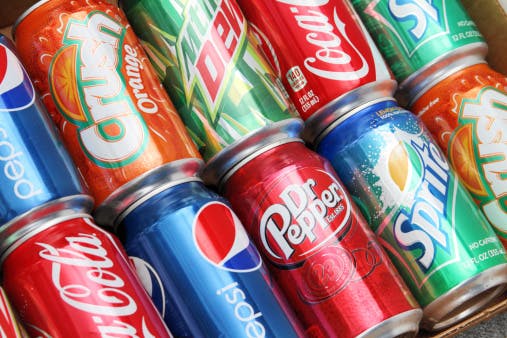 Cross section view of multiple brands of soda in aluminum cans. Brands included in this group are Coca Cola, Pepsi, Dr. Pepper, Sprite, Mountain Dew, and Orange Crush.