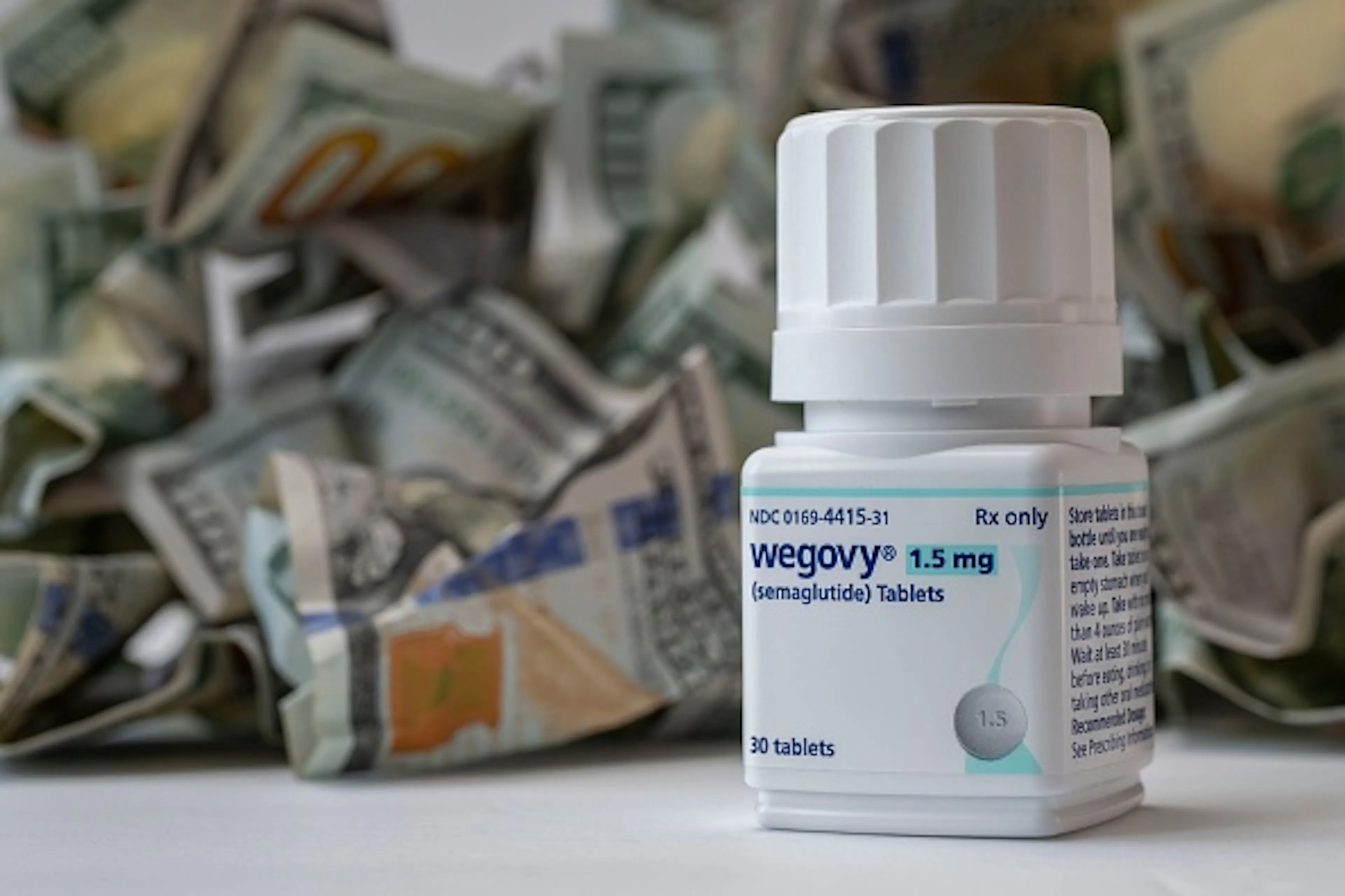  Closeup of a new bottle of Wegovy tablets with a pile of cash. Its a prescription medicine used with a reduced calorie diet and .and physical activity.